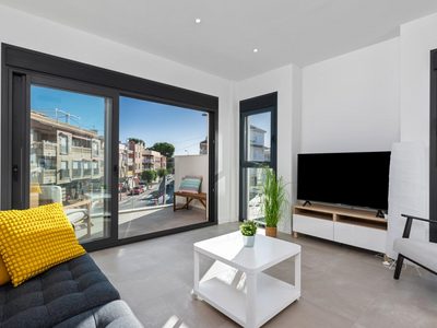 Bright living room with large glass doors opening to a balcony in Santiago De La Ribera, Murcia, Spa.