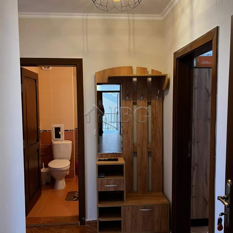 Bright hallway with wooden furniture and access to bathroom and other rooms.