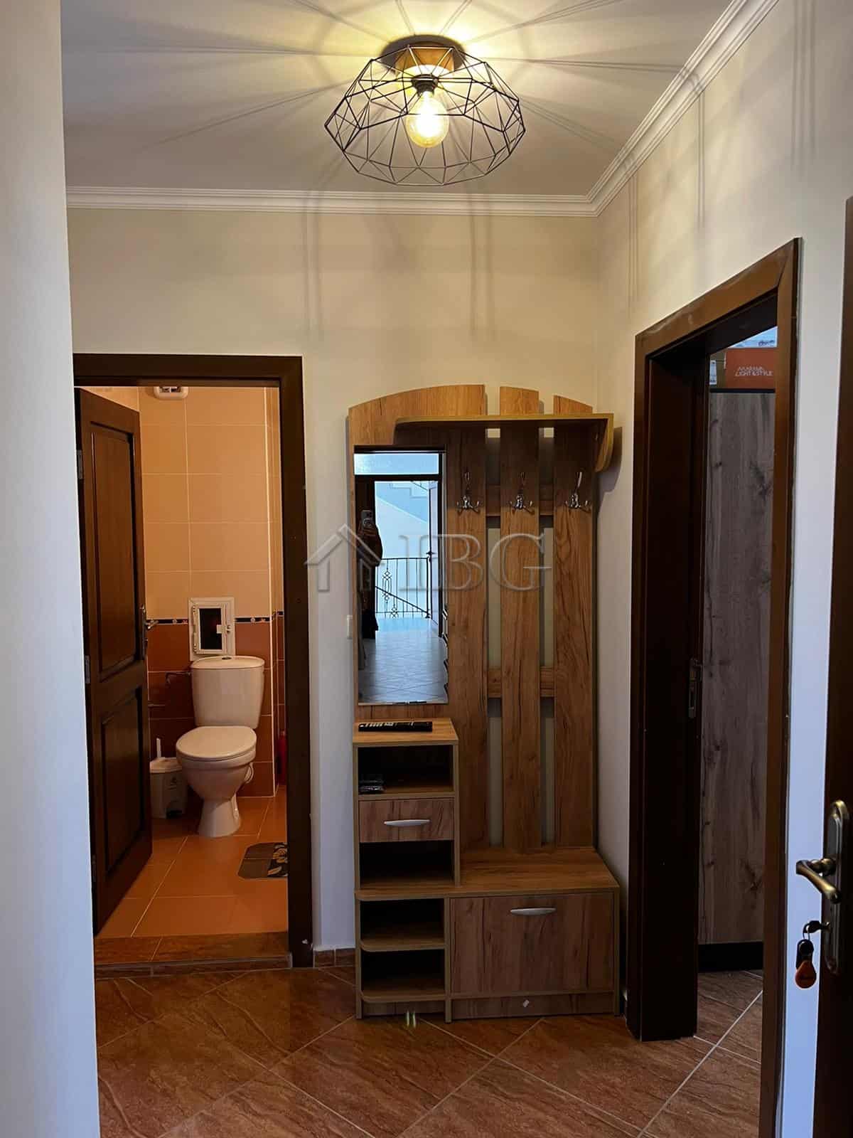 Bright hallway with wooden furniture and access to bathroom and other rooms.
