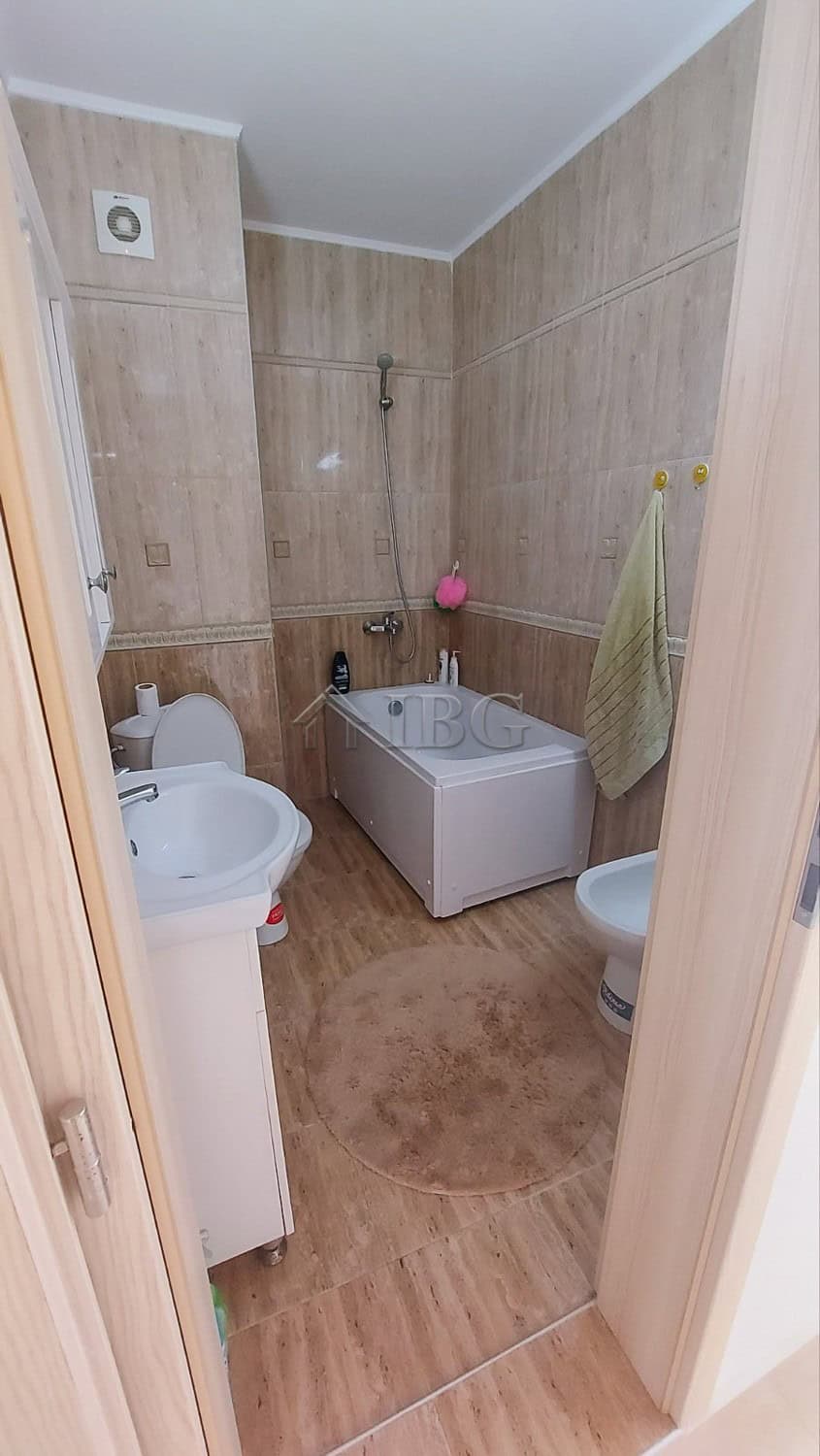 Bathroom with bathtub, toilet, and washing machine in a compact apartment.