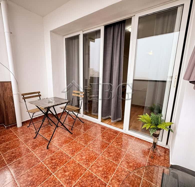 Balcony of a 2-bedroom apartment in Druzhba 2, Ruse, with outdoor furniture and potted plants.