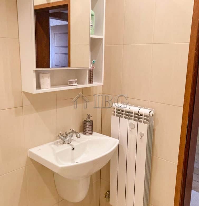 Bathroom with sink, mirror, and radiator in Ruse apartment.