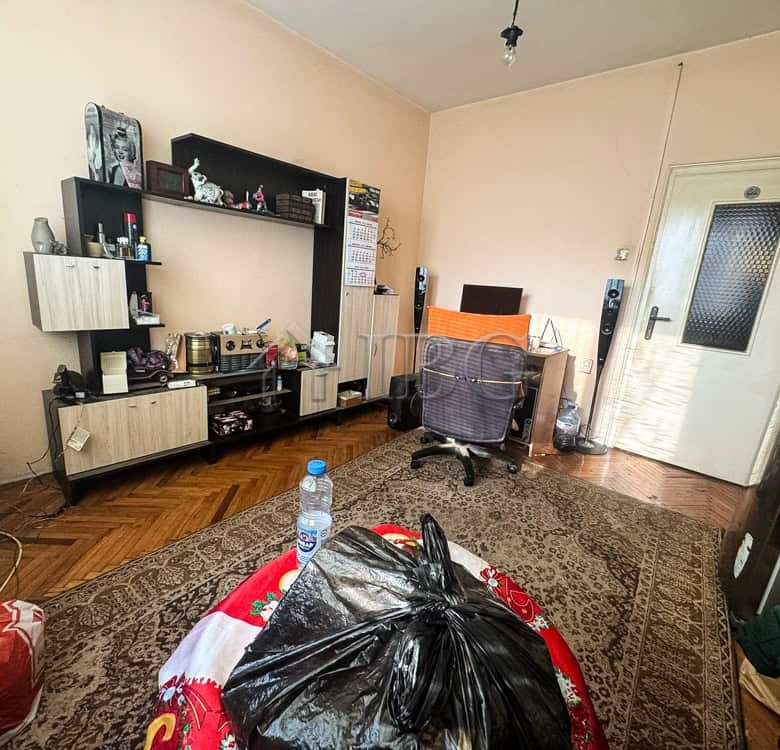 Spacious living room with furniture, shelves, and personal items in a central Ruse location.