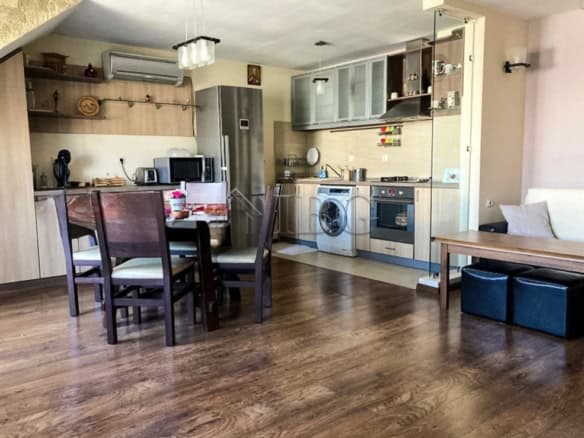 Apartment kitchen with dining table, appliances, and cozy living space.