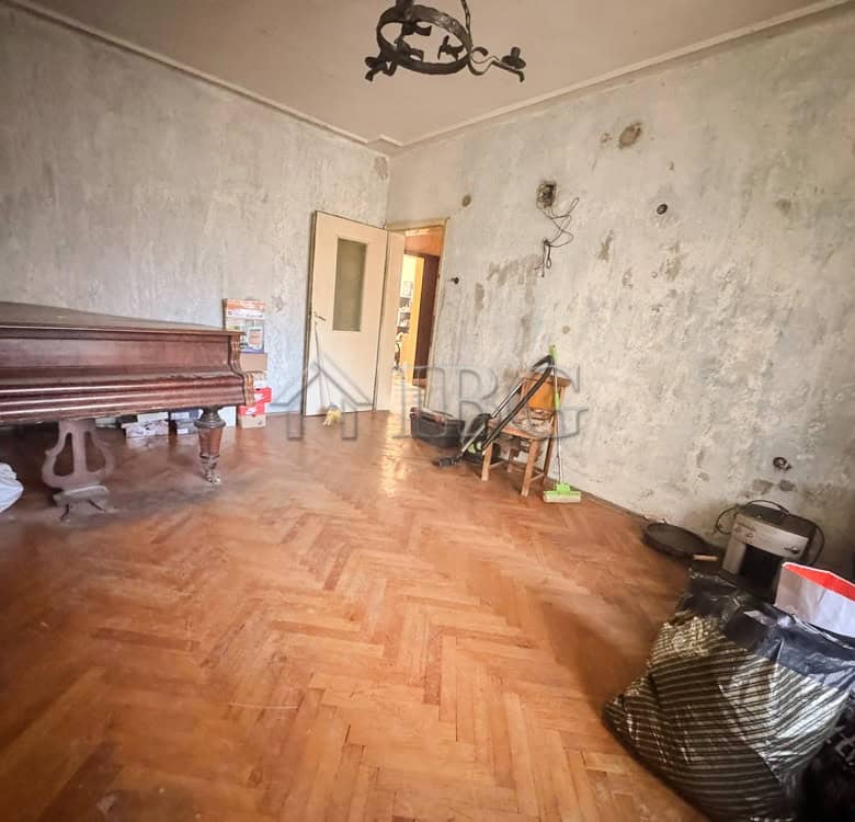 Interior of a 2-bedroom apartment in Ruse with worn walls and wooden flooring.