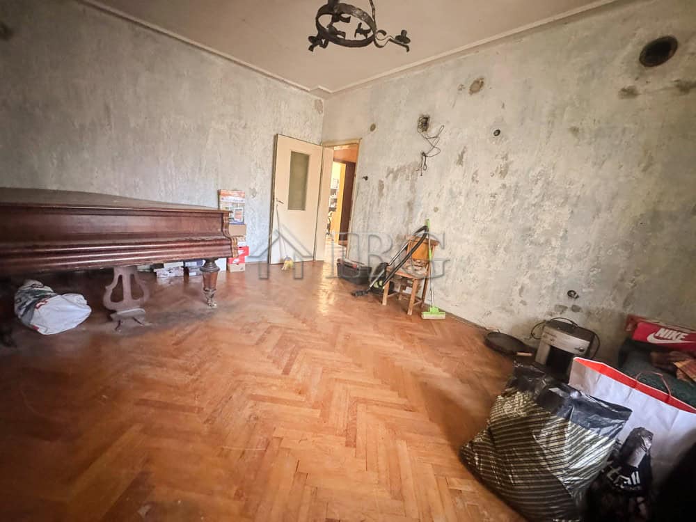 Interior of a 2-bedroom apartment in Ruse with worn walls and wooden flooring.