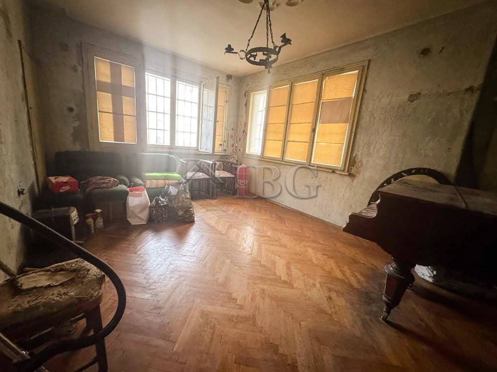 Spacious living room with large windows in a central Ruse location.