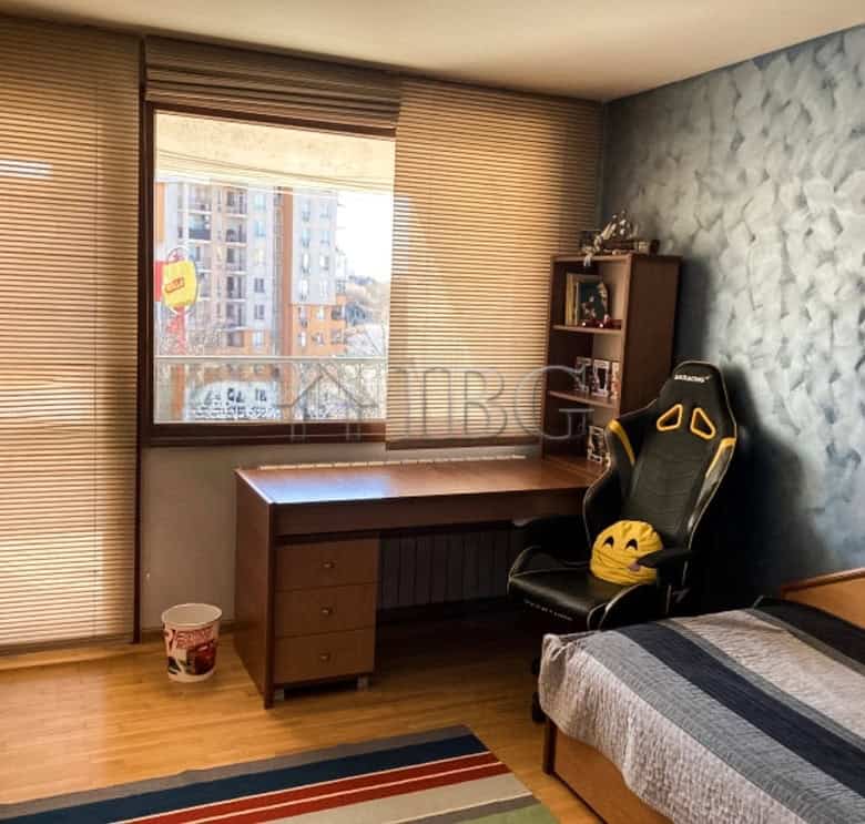 Bright interior of a two-bedroom apartment with a workspace and a comfortable bed, located close to.