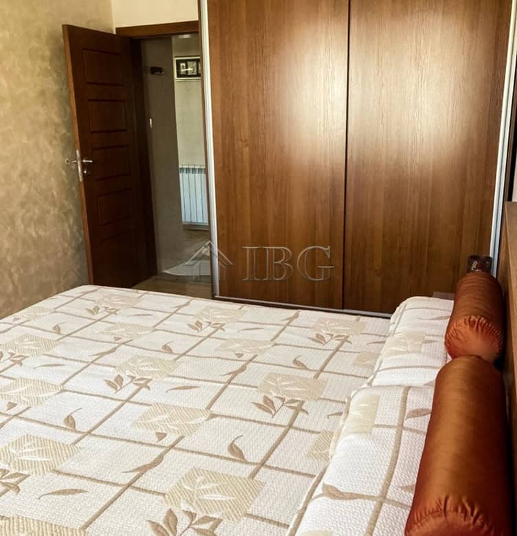 Spacious bedroom with large wardrobe and cozy bed near the top center of Ruse.