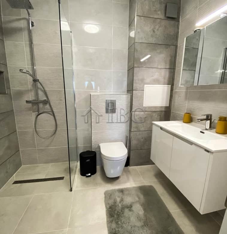 Bathroom with walk-in shower, toilet, and vanity in a stylish, modern design.