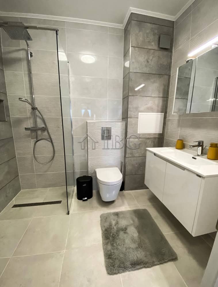 Bathroom with walk-in shower, toilet, and vanity in a stylish, modern design.