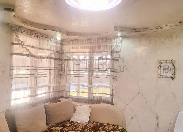 Bright interior of a renovated house with large windows and cozy furnishings.
