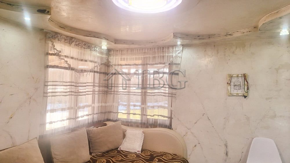 Bright interior of a renovated house with large windows and cozy furnishings.