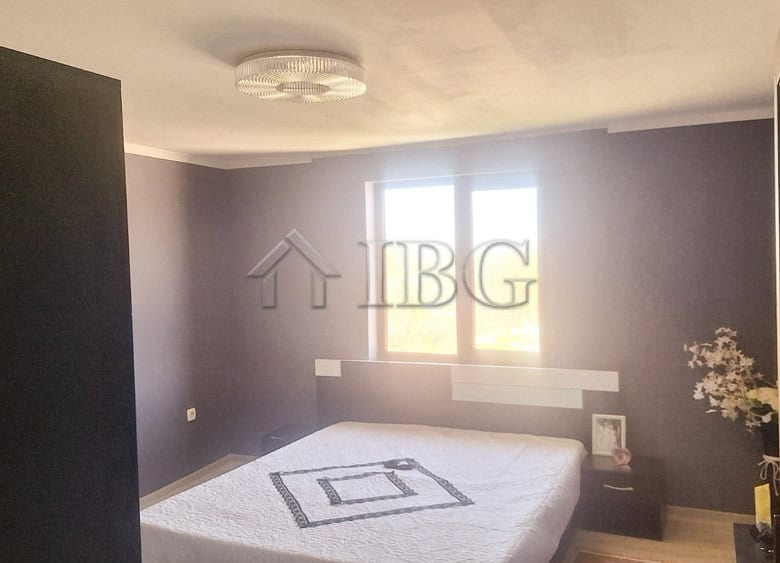 Bright bedroom with large window and modern decor, showcasing a spacious interior near the quiet are.