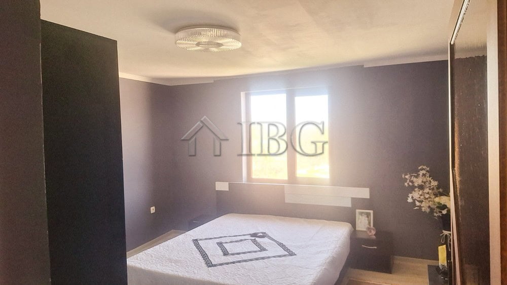 Bright bedroom with large window and modern decor, showcasing a spacious interior near the quiet are.