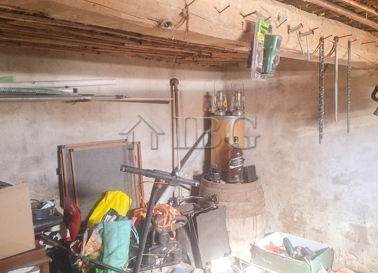 Interior view of a renovated house showing a storage space with tools, furniture, and household item.