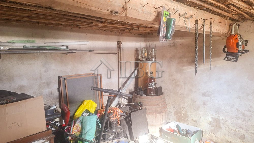Interior view of a renovated house showing a storage space with tools, furniture, and household item.