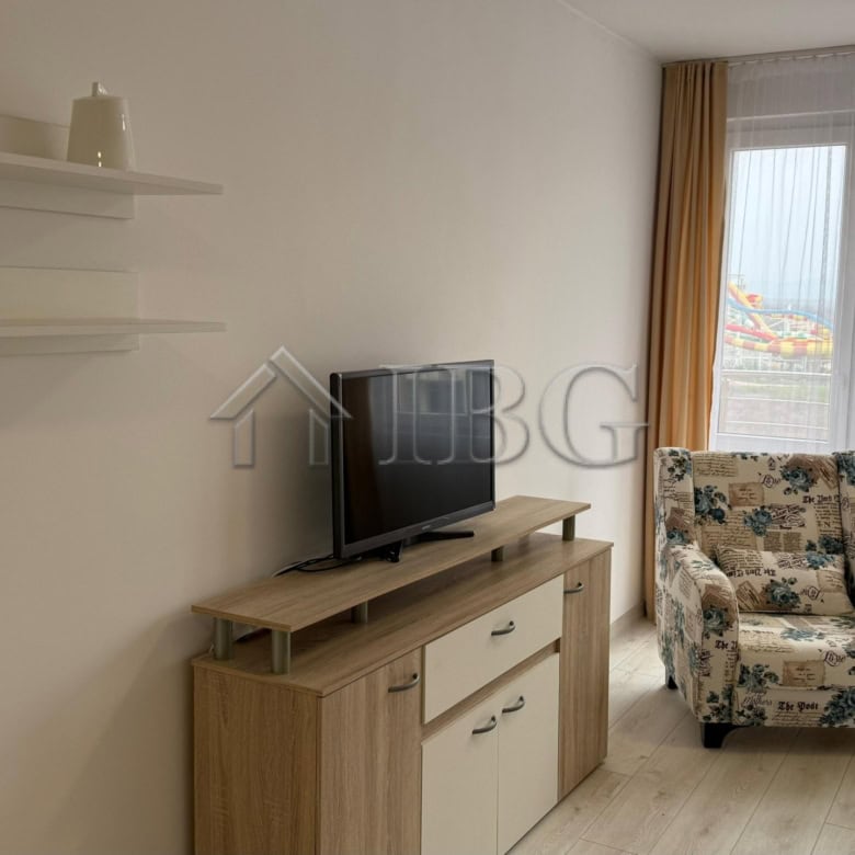 Interior view of a 1-bedroom apartment at Pomorie Beach Resort with a living area and large windows.