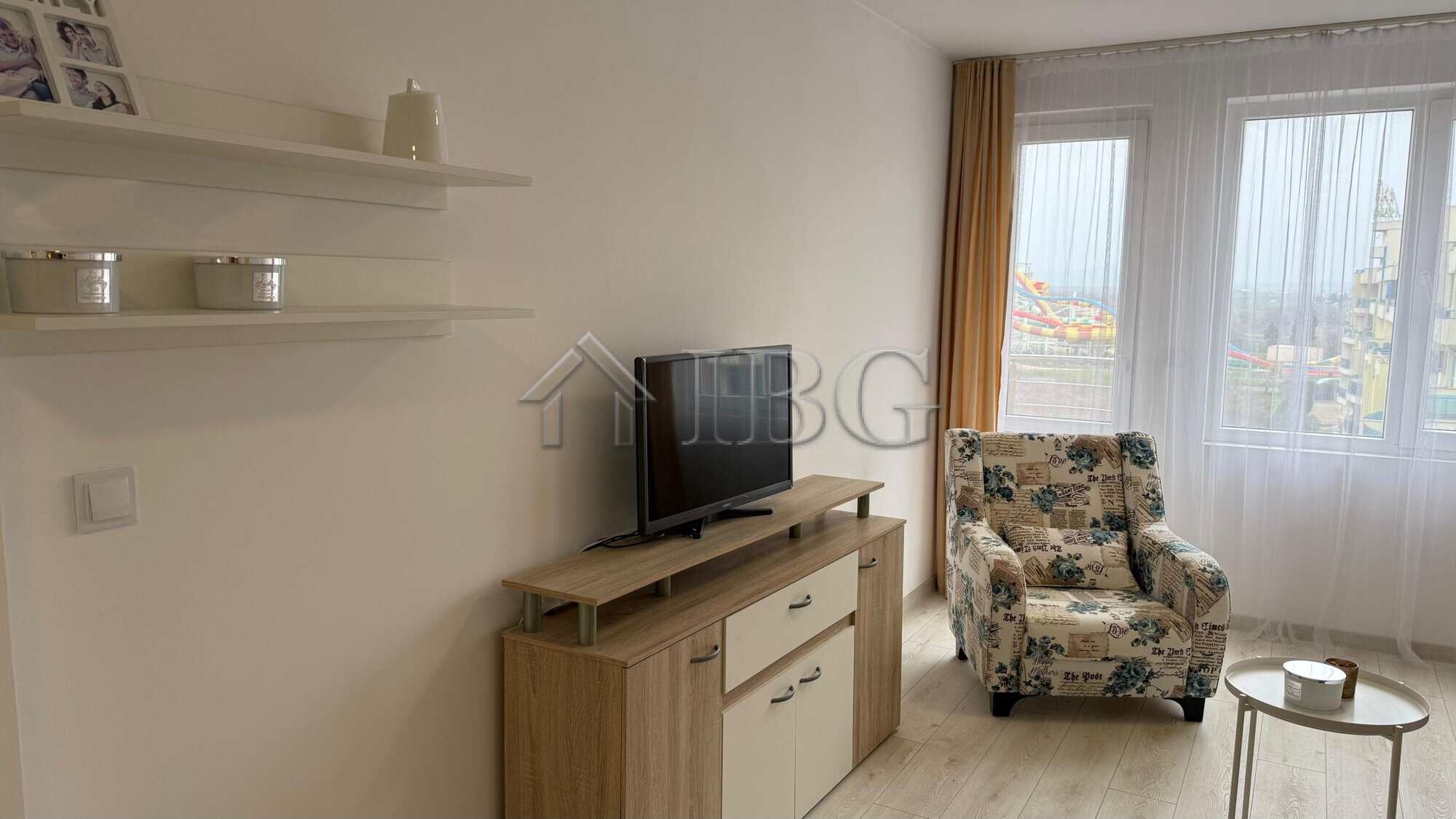Interior view of a 1-bedroom apartment at Pomorie Beach Resort with a living area and large windows.
