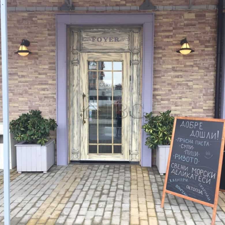 Equipped exclusive restaurant entrance with rustic wooden door and welcoming signage in Nessebar.
