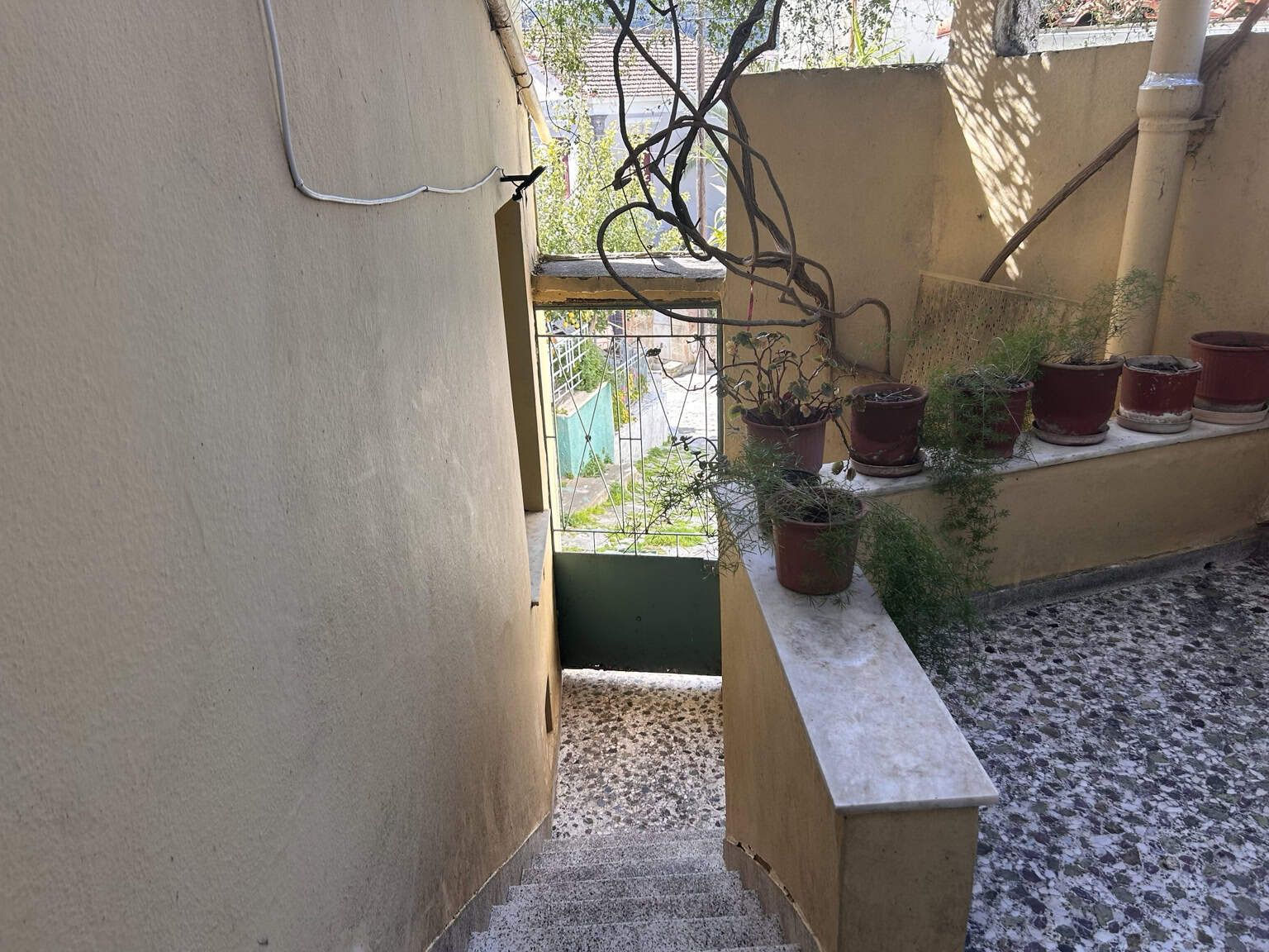 Outdoor terrace with potted plants and garden scenery, perfect for relaxing or gardening activities.