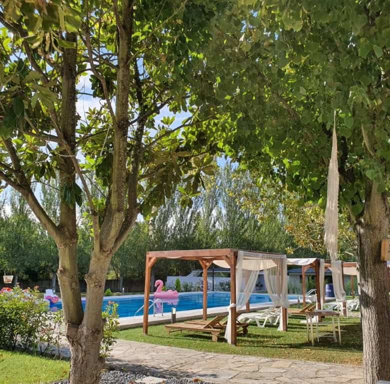 Beautiful outdoor view of a luxury finca with pool and shaded lounging area in Leon, Spain.
