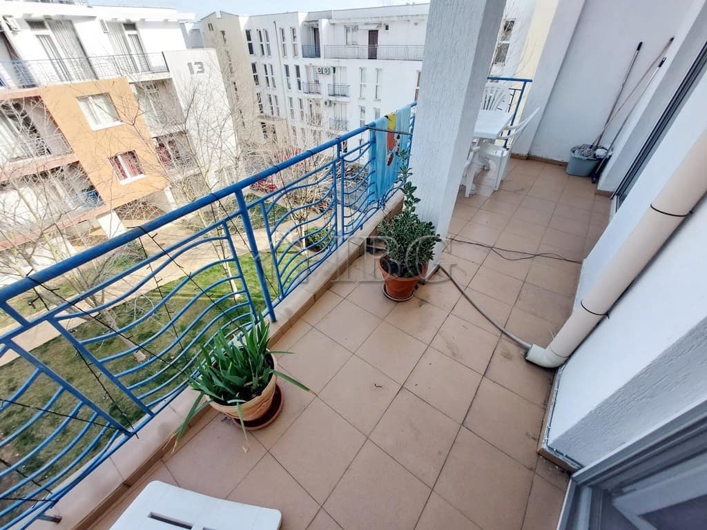 Balcony with potted plants and outdoor furniture in a sunny apartment in Sunny Beach.
