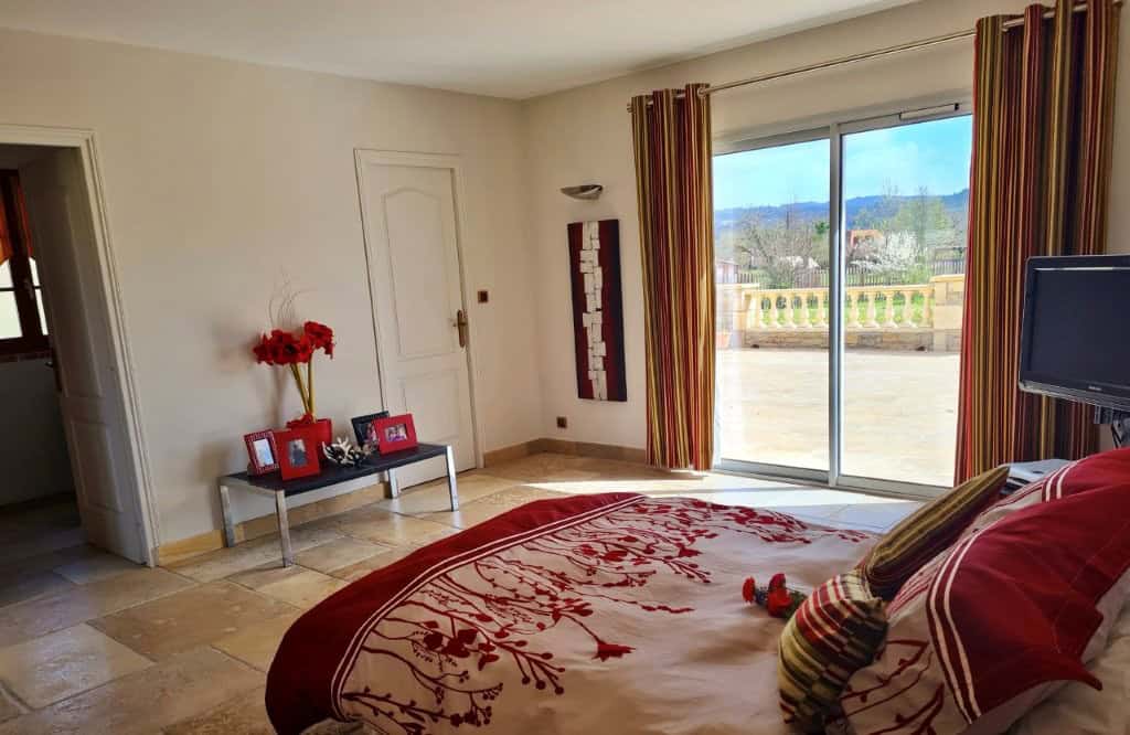 Luxury 4 Bed Le Manoir House Elegant bedroom with large windows and scenic views in Dordogne Valley.