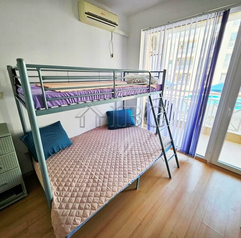 Cozy studio apartment featuring a bunk bed, balcony, and pool view in Sunny Beach. Perfect for a rel.