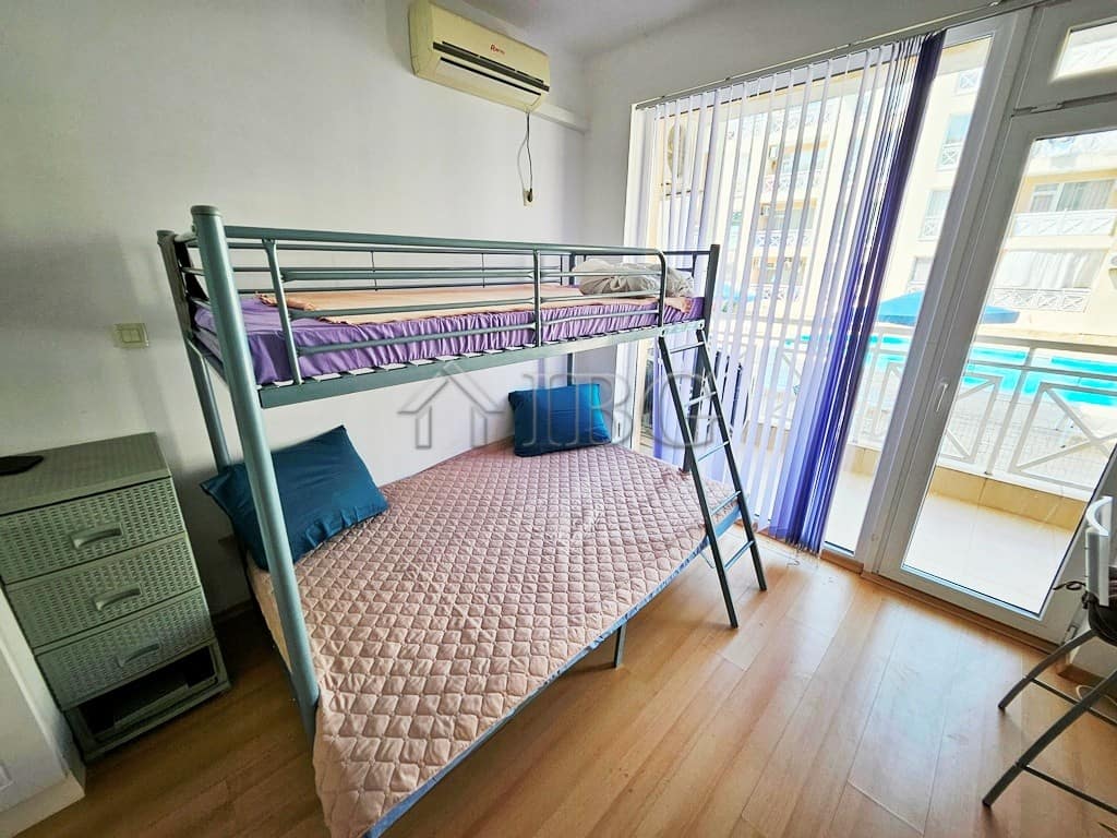 Cozy studio apartment featuring a bunk bed, balcony, and pool view in Sunny Beach. Perfect for a rel.