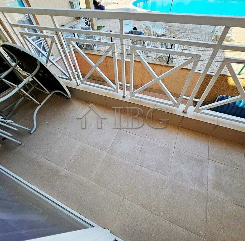 Balcony with pool view in a bright studio apartment, perfect for relaxing sunny days at Sunny Beach.