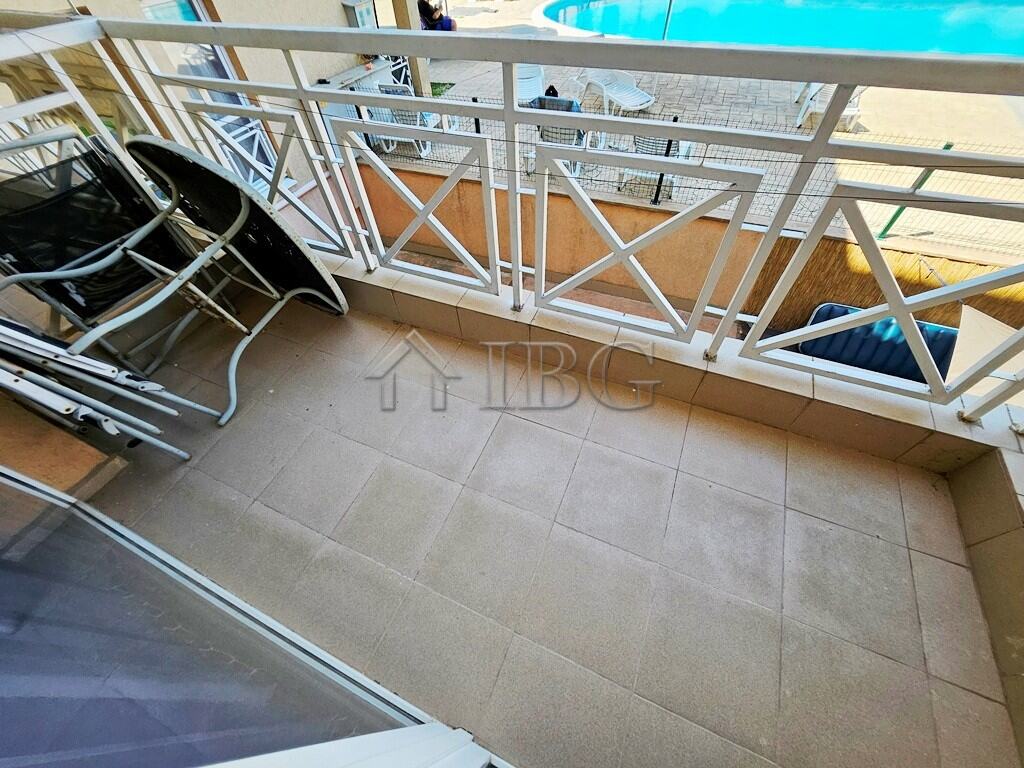 Balcony with pool view in a bright studio apartment, perfect for relaxing sunny days at Sunny Beach.