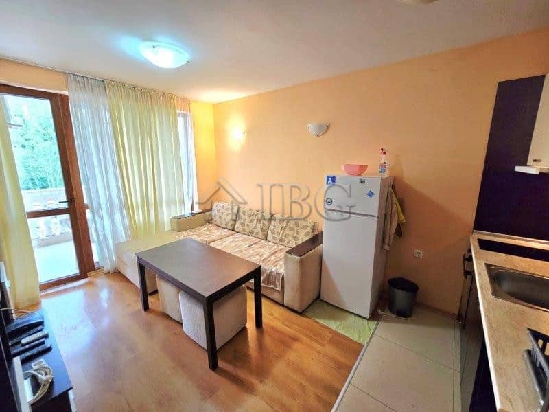 Bright apartment with a pool view, featuring a living room, small dining area, and balcony access.