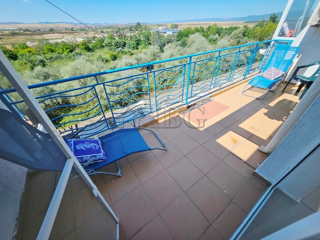 Balcony of a 2-bedroom maisonette apartment overlooking lush greenery and scenic landscape in Sunny.