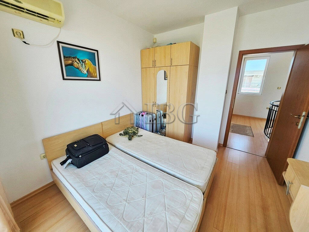 Bright bedroom with twin beds and wardrobe in Sunny Beach apartment.
