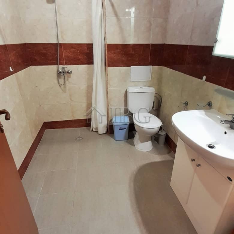 Small bathroom with shower, toilet, and sink in a modern apartment.