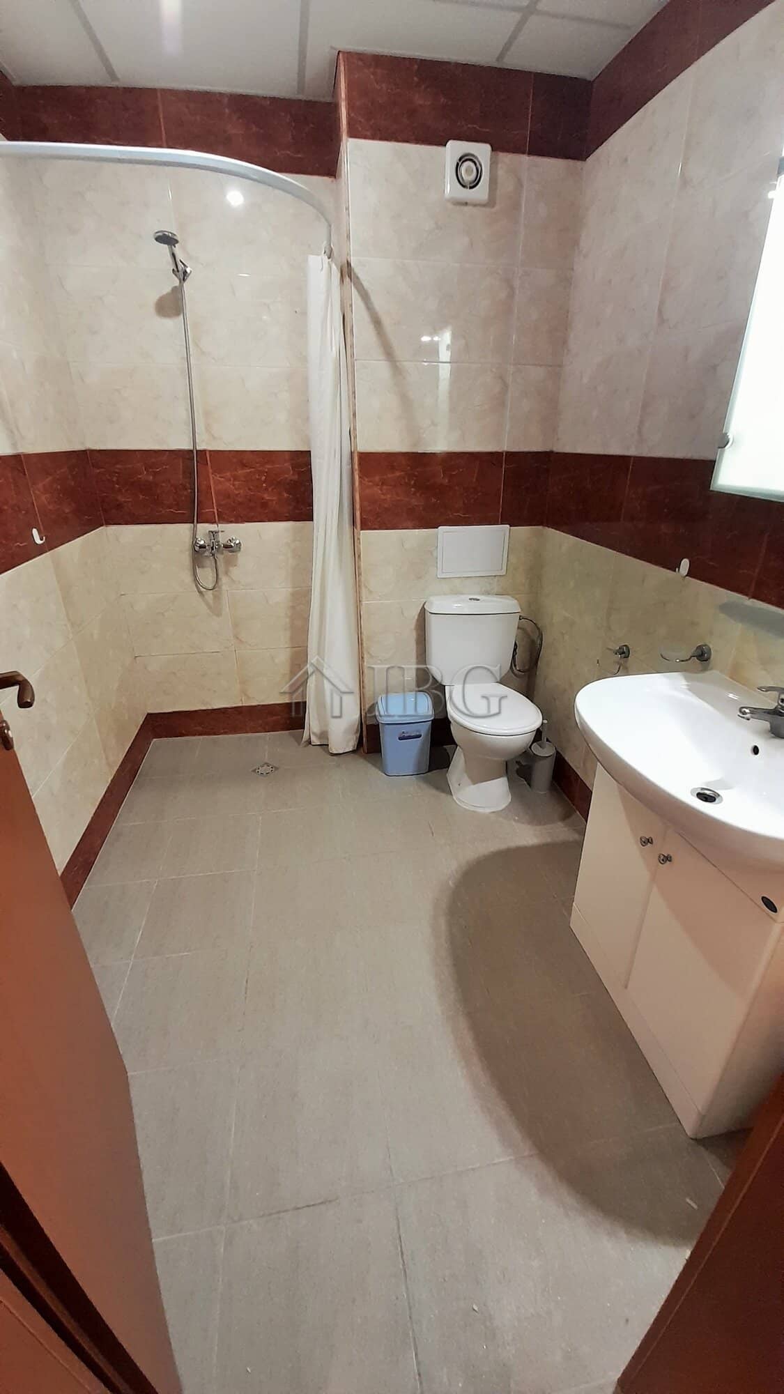 Small bathroom with shower, toilet, and sink in a modern apartment.