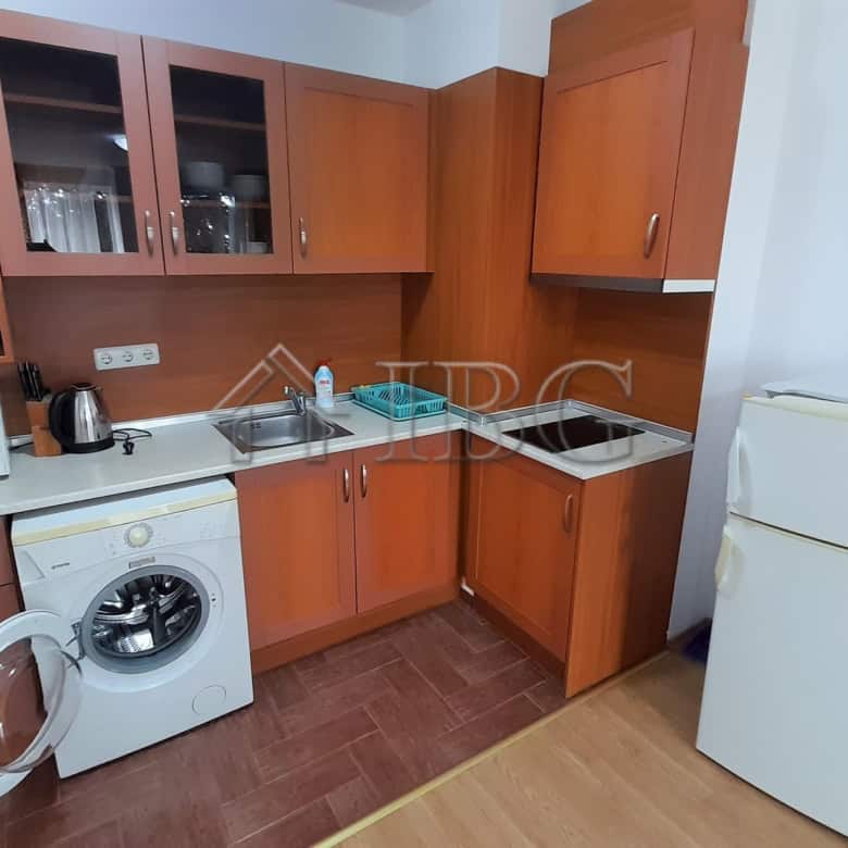 Interior of a one-bedroom apartment with kitchen, washing machine, and fridge near Riviera Fort Beac.