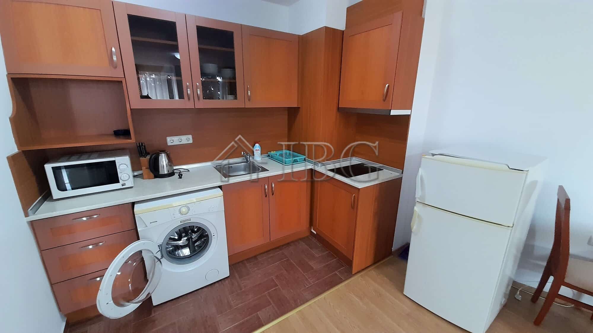 Interior of a one-bedroom apartment with kitchen, washing machine, and fridge near Riviera Fort Beac.