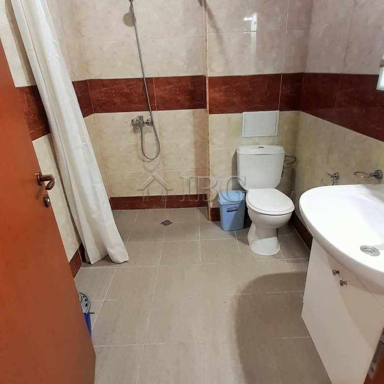 Bathroom with shower, toilet, and sink in a small apartment near the sea.