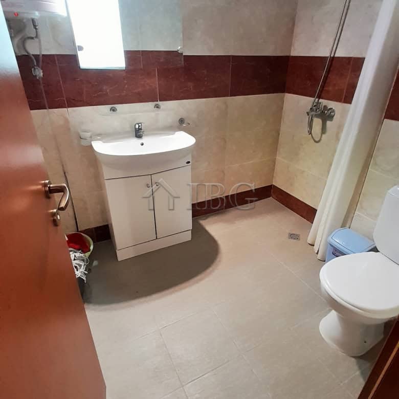 Modern bathroom in a one-bedroom apartment with shower, sink, and toilet.