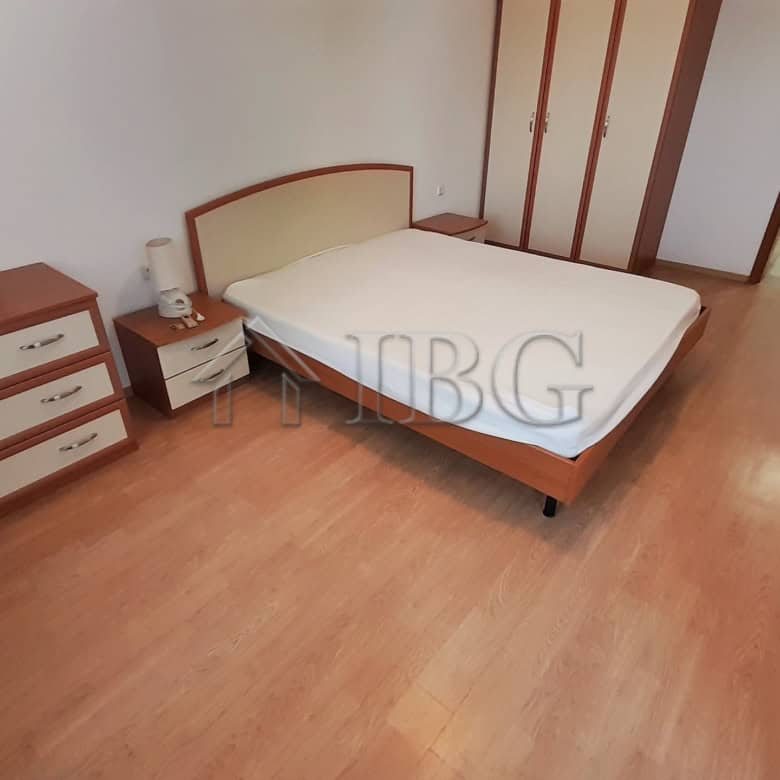Comfortable bedroom featuring a double bed, wooden dresser, and ample natural light from a nearby wi.