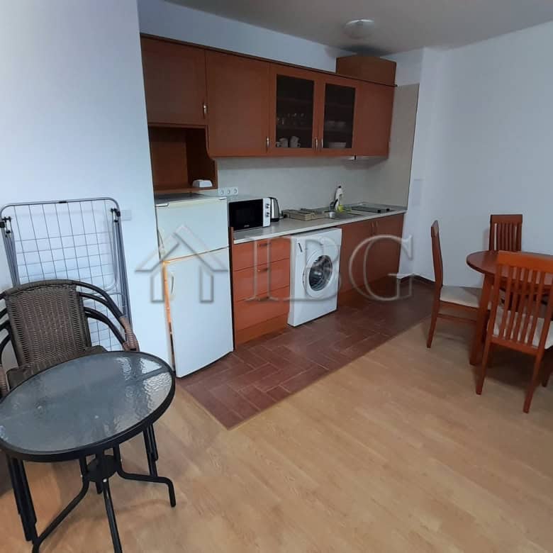 Interior of a one-bedroom apartment with a small kitchen, dining area, and sea view in Ravda.