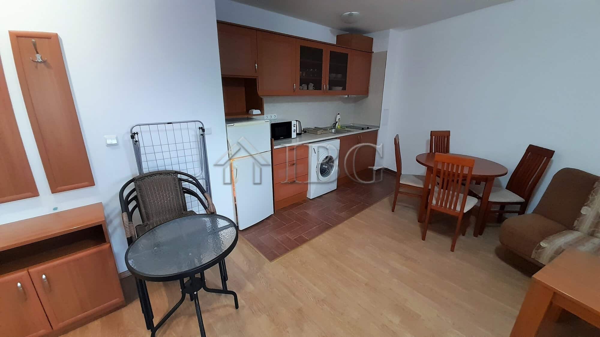 Interior of a one-bedroom apartment with a small kitchen, dining area, and sea view in Ravda.