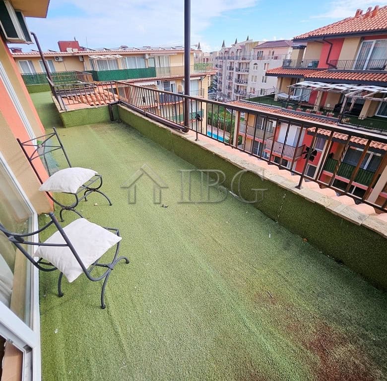 Spacious balcony with seating overlooking Sunny Beach's vibrant neighborhood. Perfect for relaxing a.
