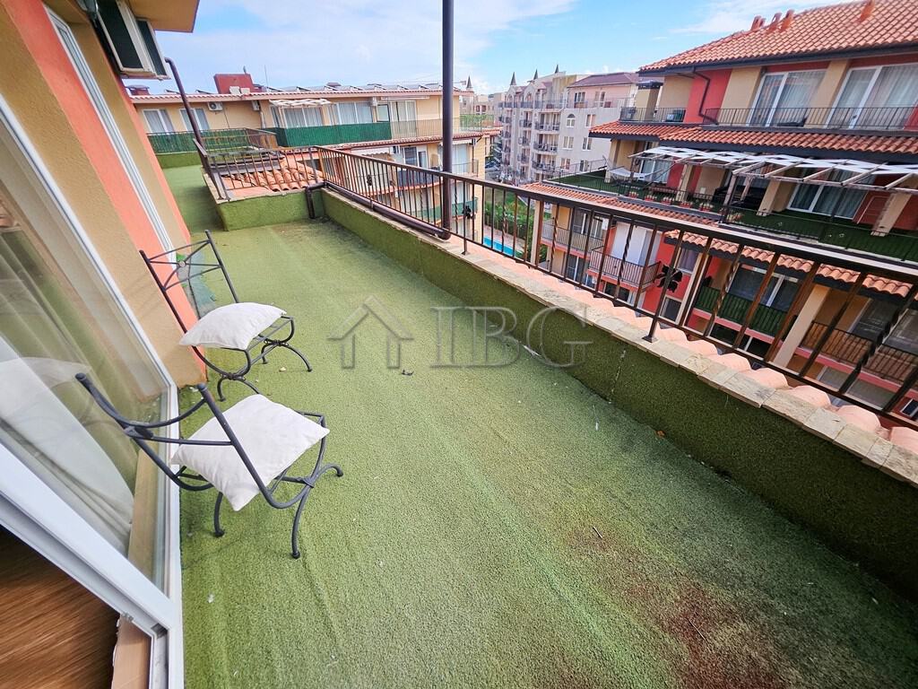 Spacious balcony with seating overlooking Sunny Beach's vibrant neighborhood. Perfect for relaxing a.