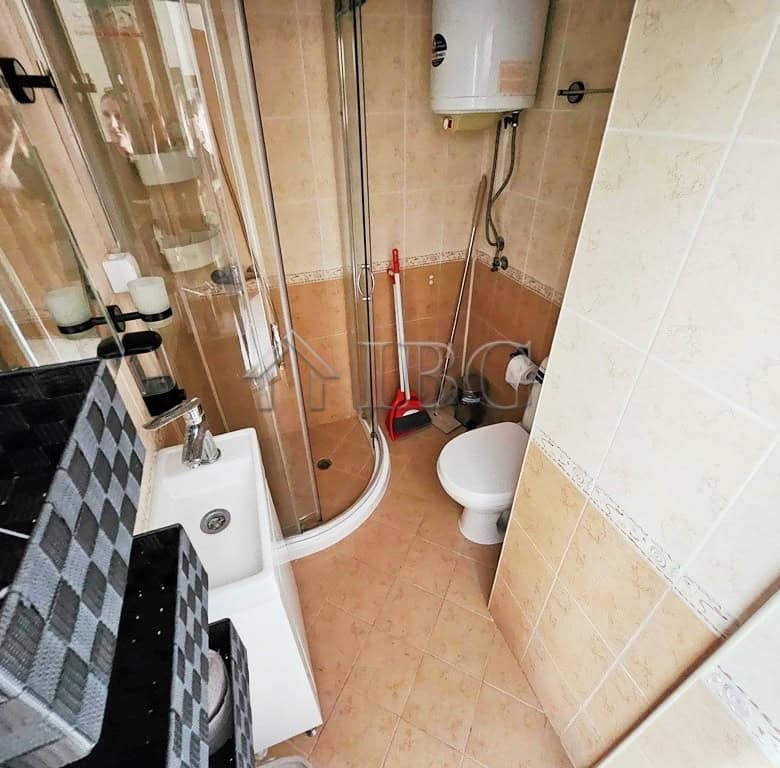 Small bathroom in a 2-room apartment in Pirop City, Sunny Beach, with shower, toilet, and sink.