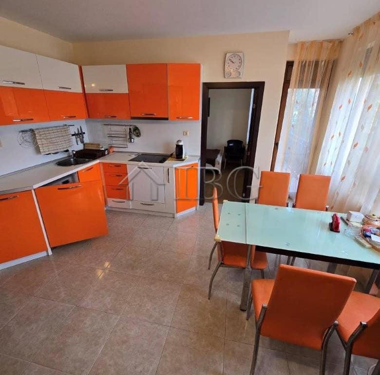 Bright kitchen with orange cabinets and a dining table in Elitonia 2, Ravda, Bulgaria.