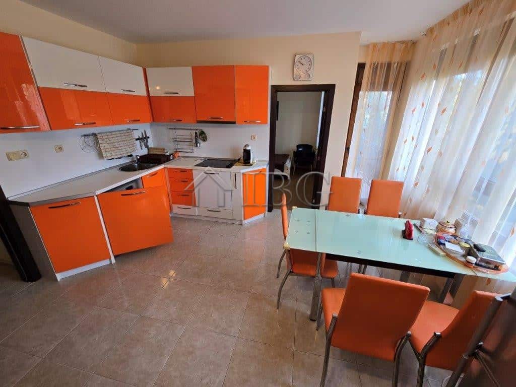 Bright kitchen with orange cabinets and a dining table in Elitonia 2, Ravda, Bulgaria.