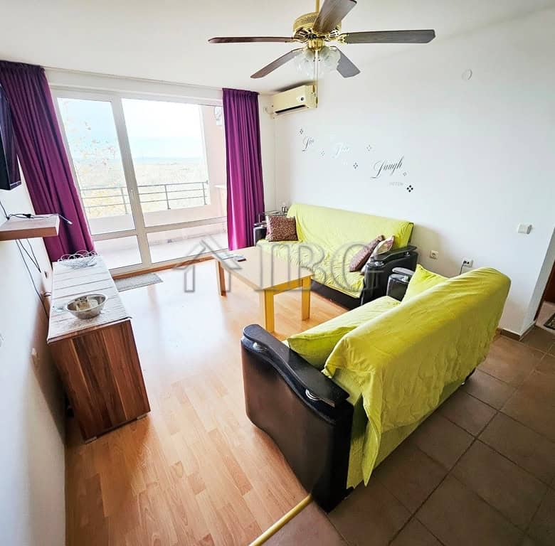 Bright living room with balcony view at Holiday Fort Golf Club.